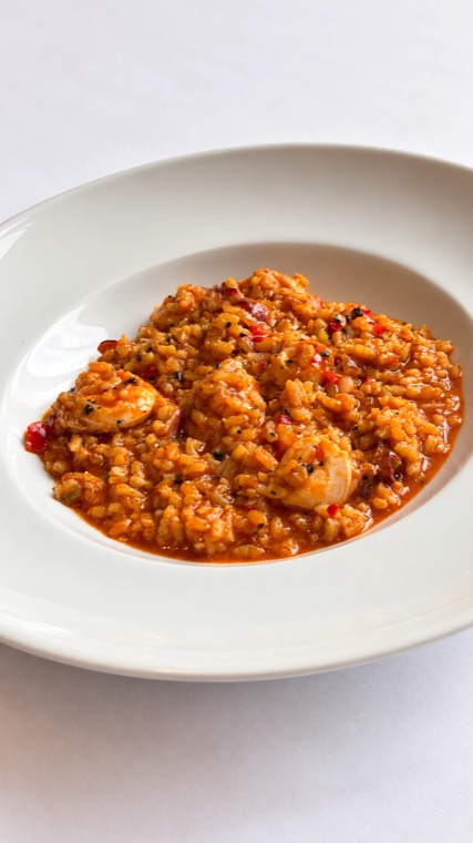 Creamy rice in red sauce with peppers