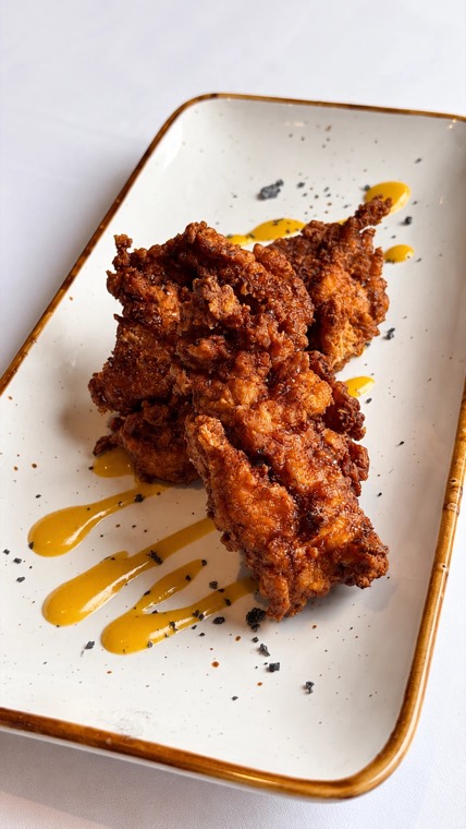 Crispy fried chicken with yellow sauce and black salt
